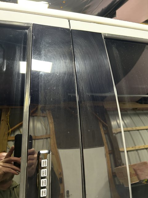 Gloss black pillar trim on a white F-150 covered in swirl marks and scratches