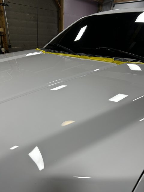 Silver truck hood with a deep gloss after paint correction and ceramic coating