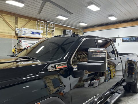 Side of a black GMC Sierra HD reflecting the shop like a mirror after ceramic coating